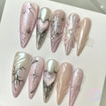 elegant pink iridescent long stiletto press on nails with glitter and star burst and metallic hearts