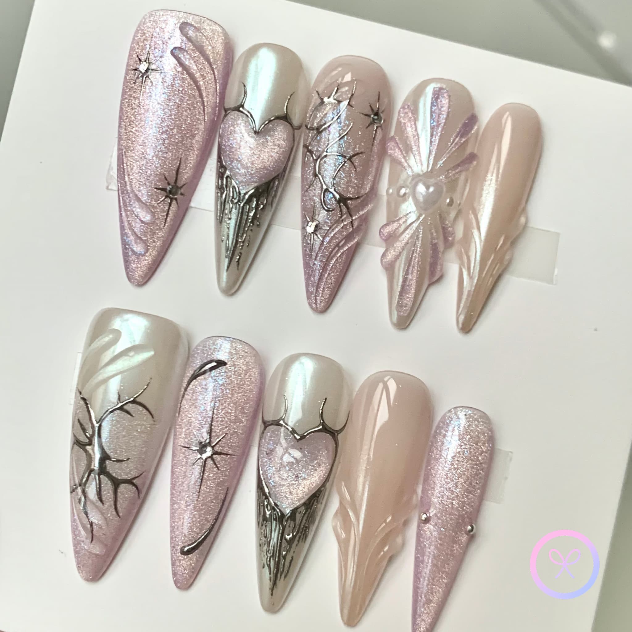 elegant pink iridescent long stiletto press on nails with glitter and star burst and metallic hearts