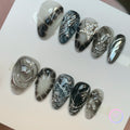 gothic black glossy short almond press on nails with chrome swirls and bloom scale