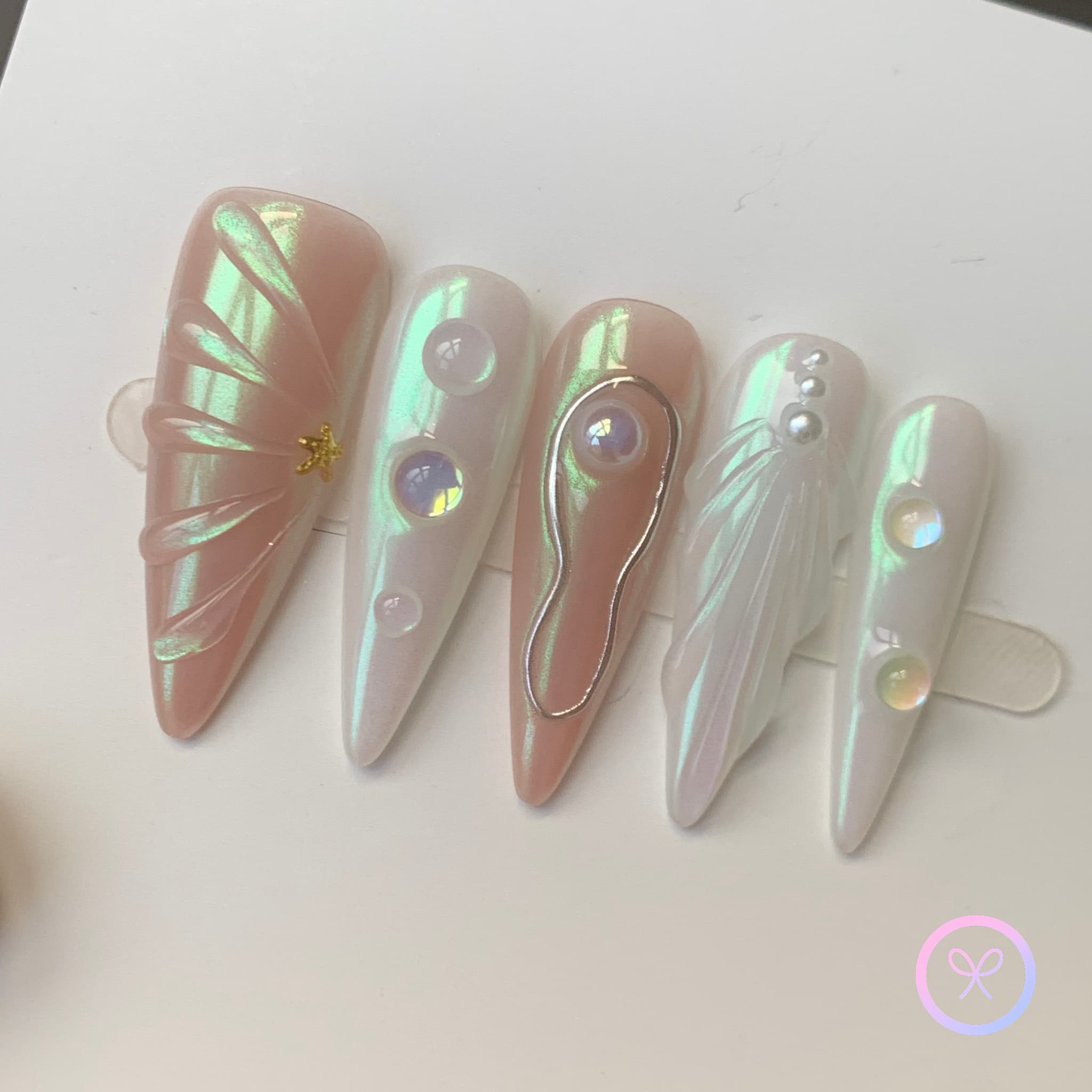 pearlcore white iridescent long stiletto press on nails with pearls and swirls that look like seashells