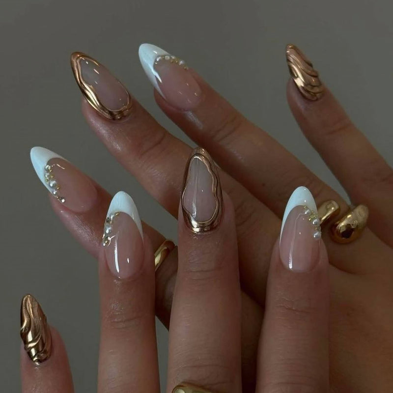 elegant nude chrome short almond press on nails with swirls and pearl motif. french tips and golden chrome