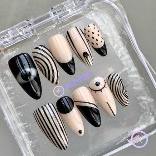 abstract black and nude glossy long stiletto press on nails with eye and stripe design