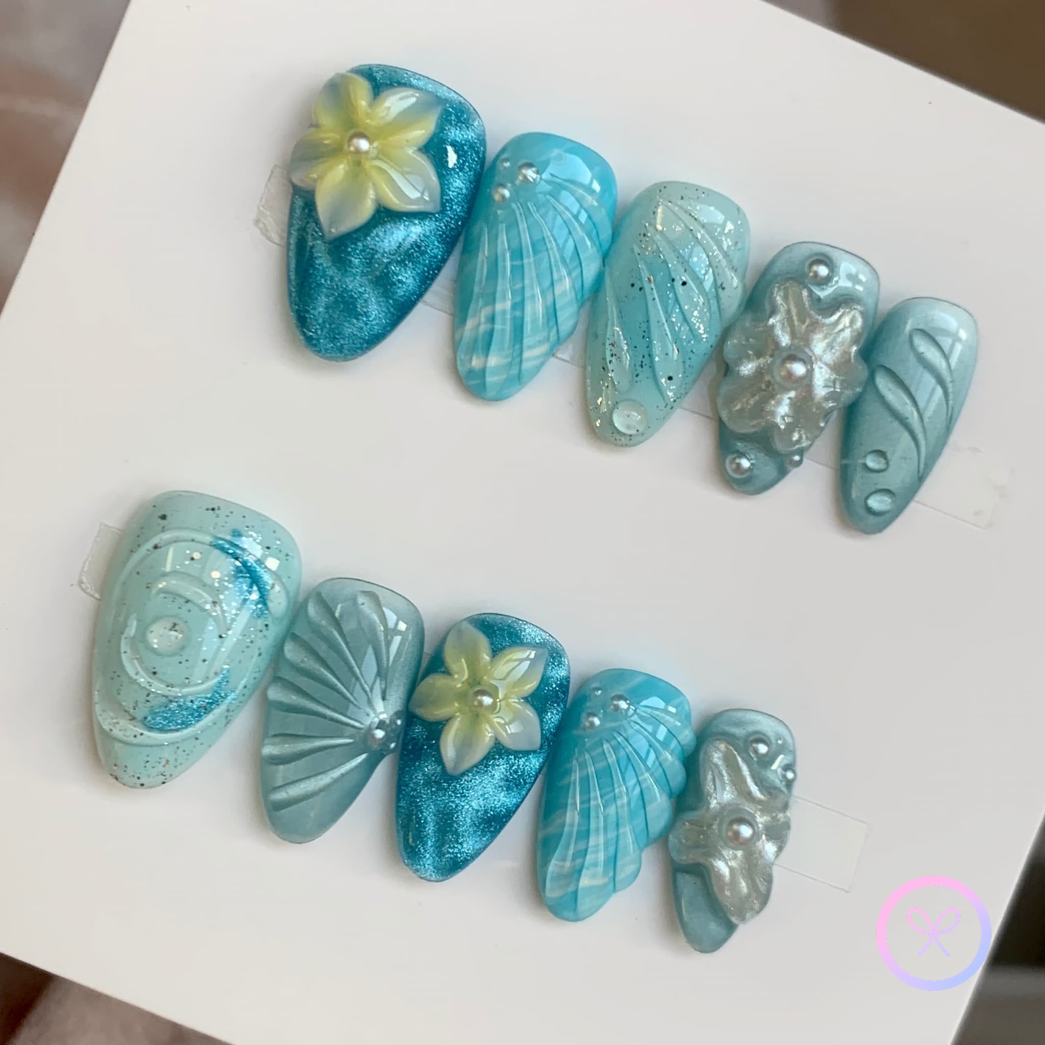oceanic blue glossy short almond press on nails with water ripple effect and embossed flowers