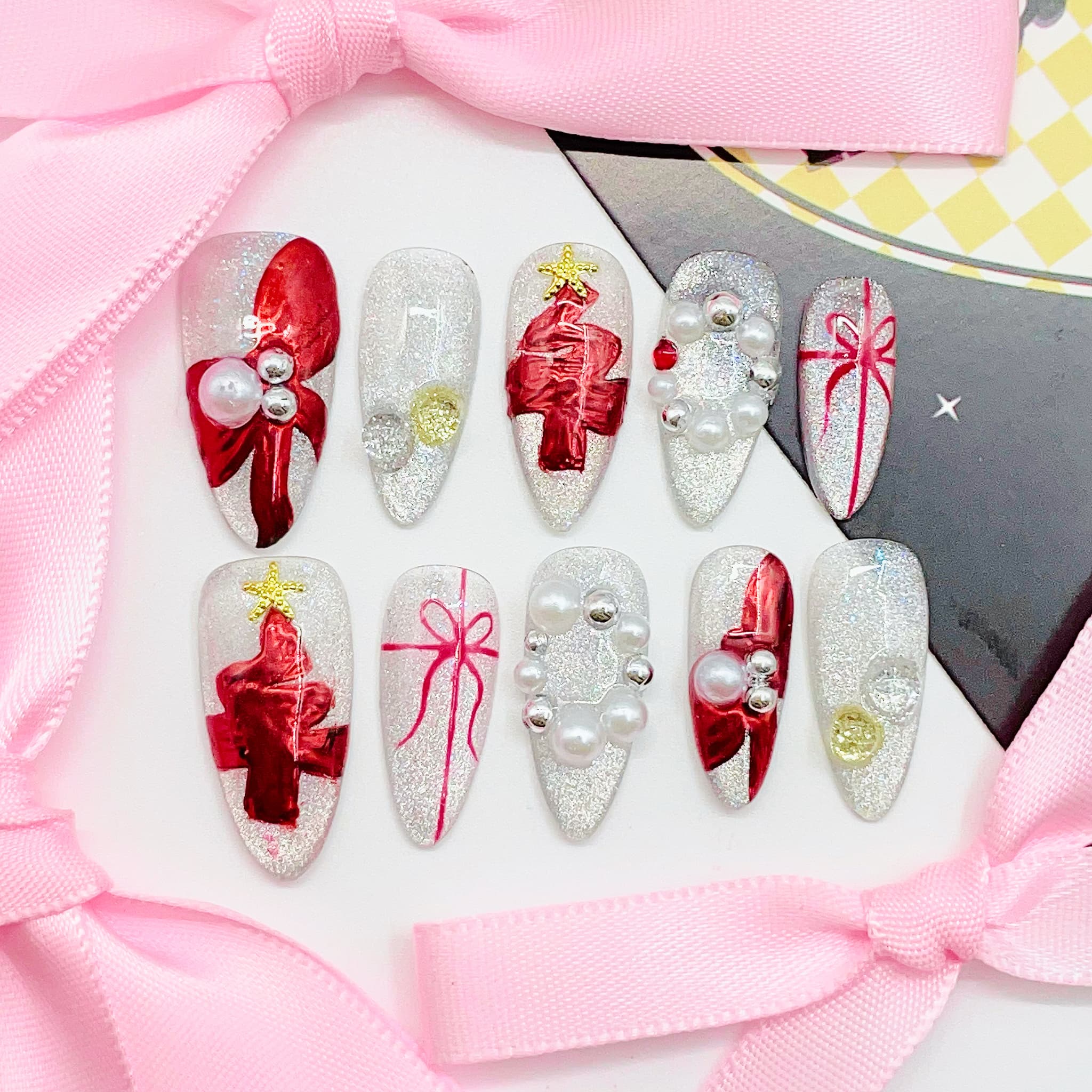 Decorative nail art with red bows and pearls