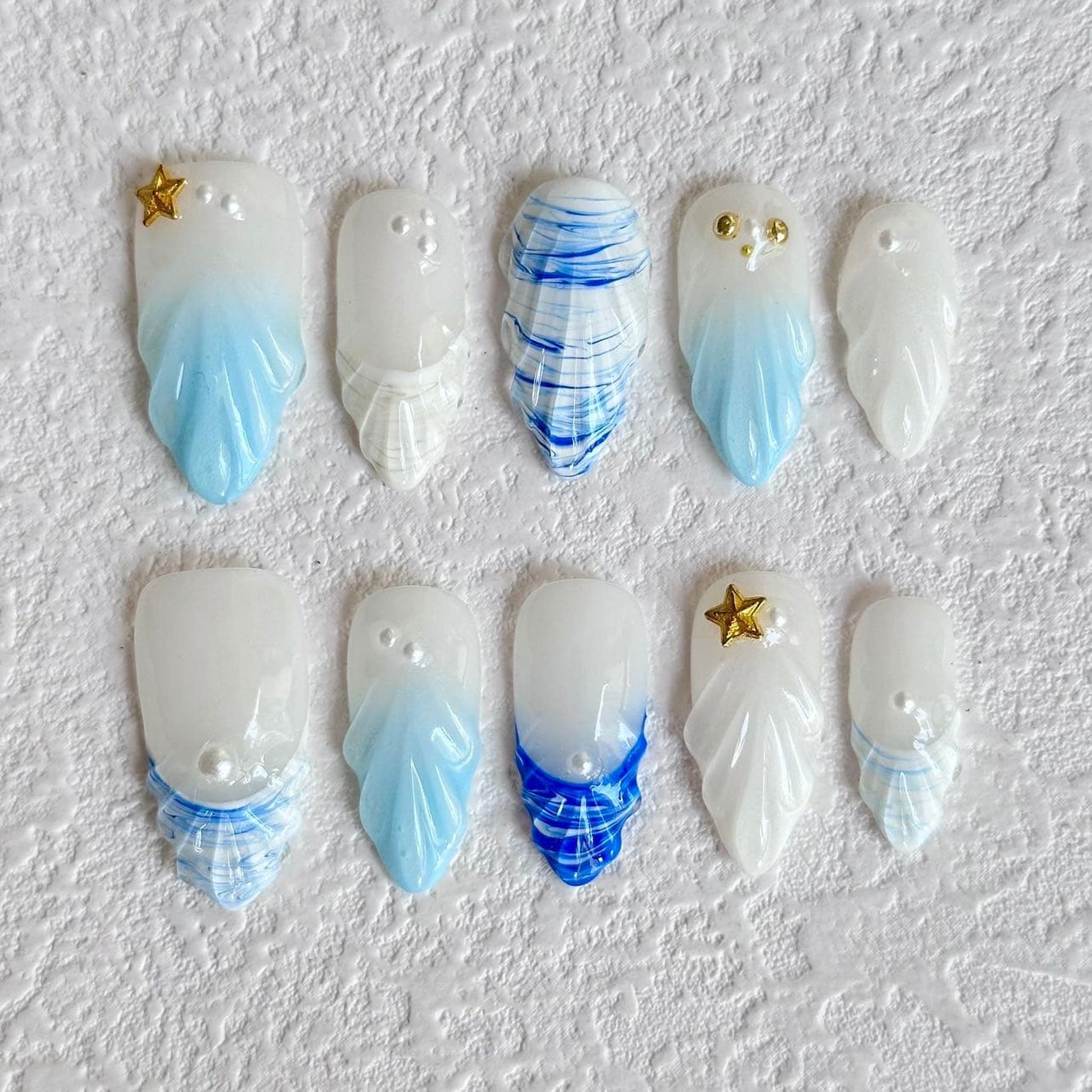 medium length light blue press on nails with seashell designs