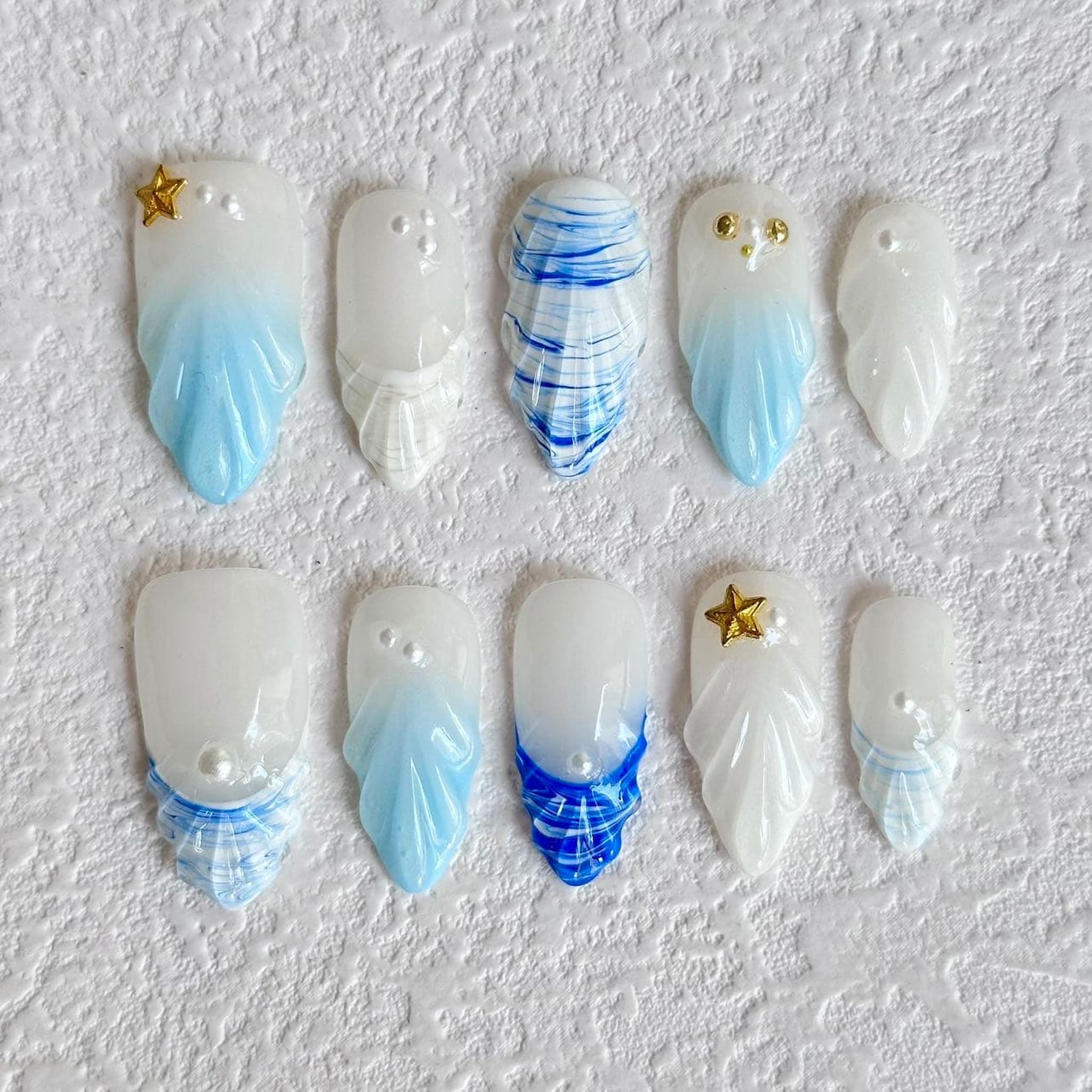 medium length light blue press on nails with seashell designs