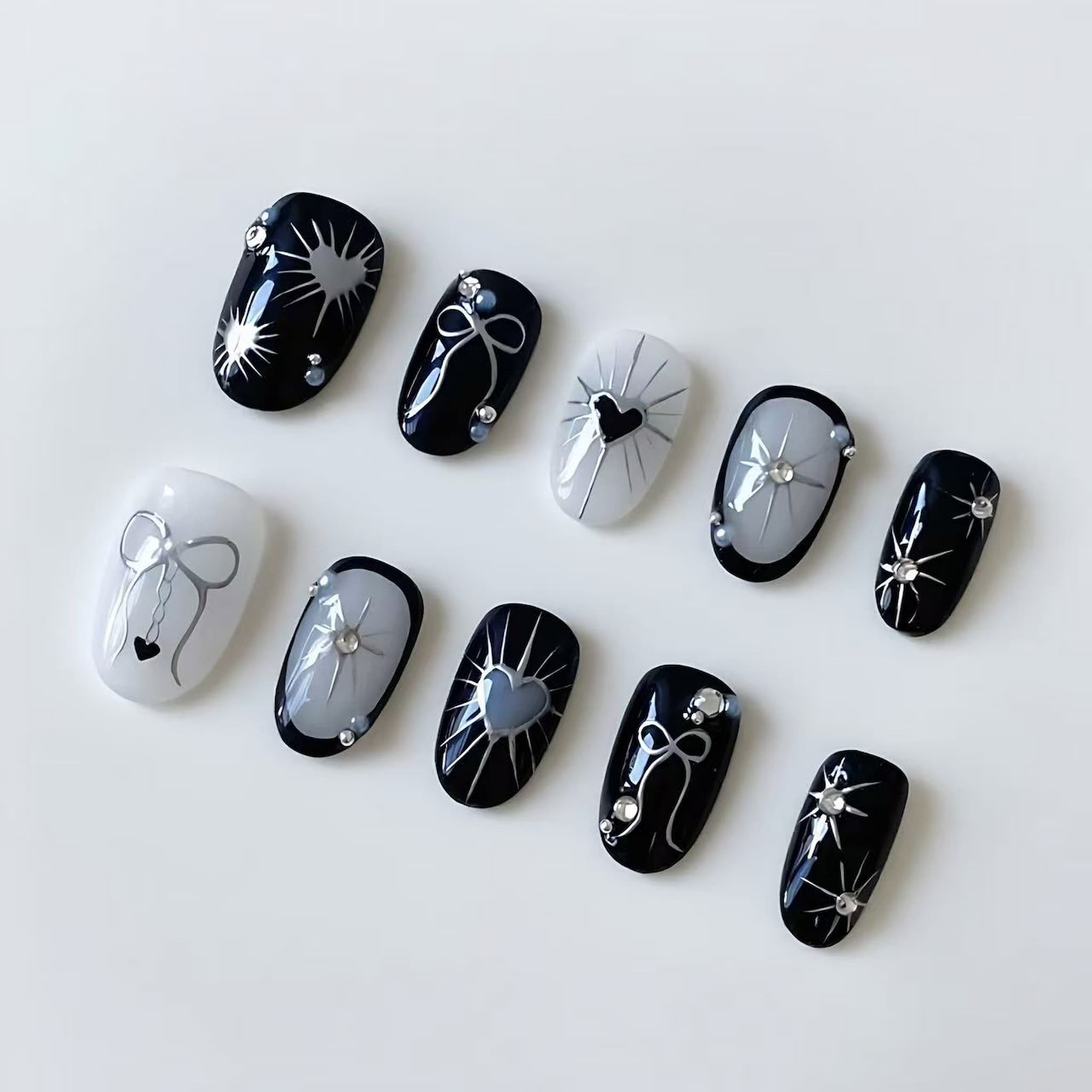 short length black oval press on nails with gothic and heart designs