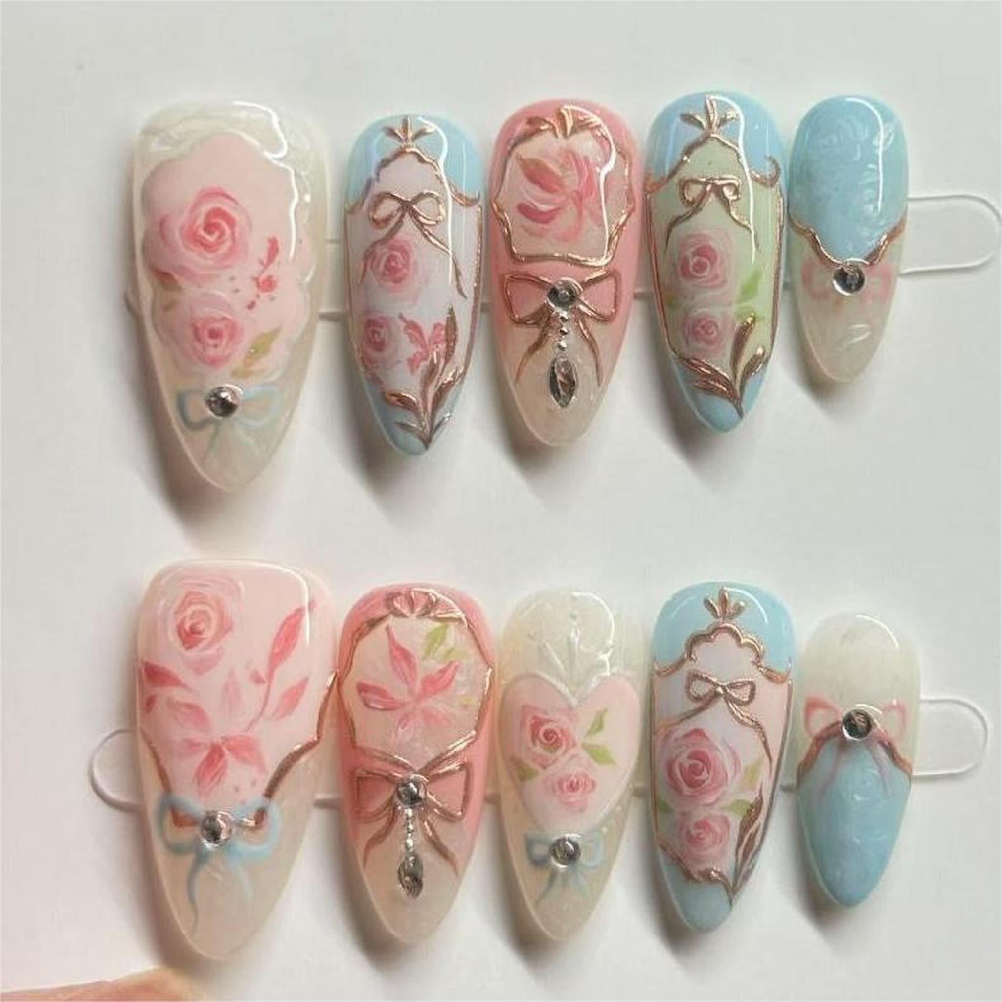 medium length light pink almond press on nails with rococo style design
