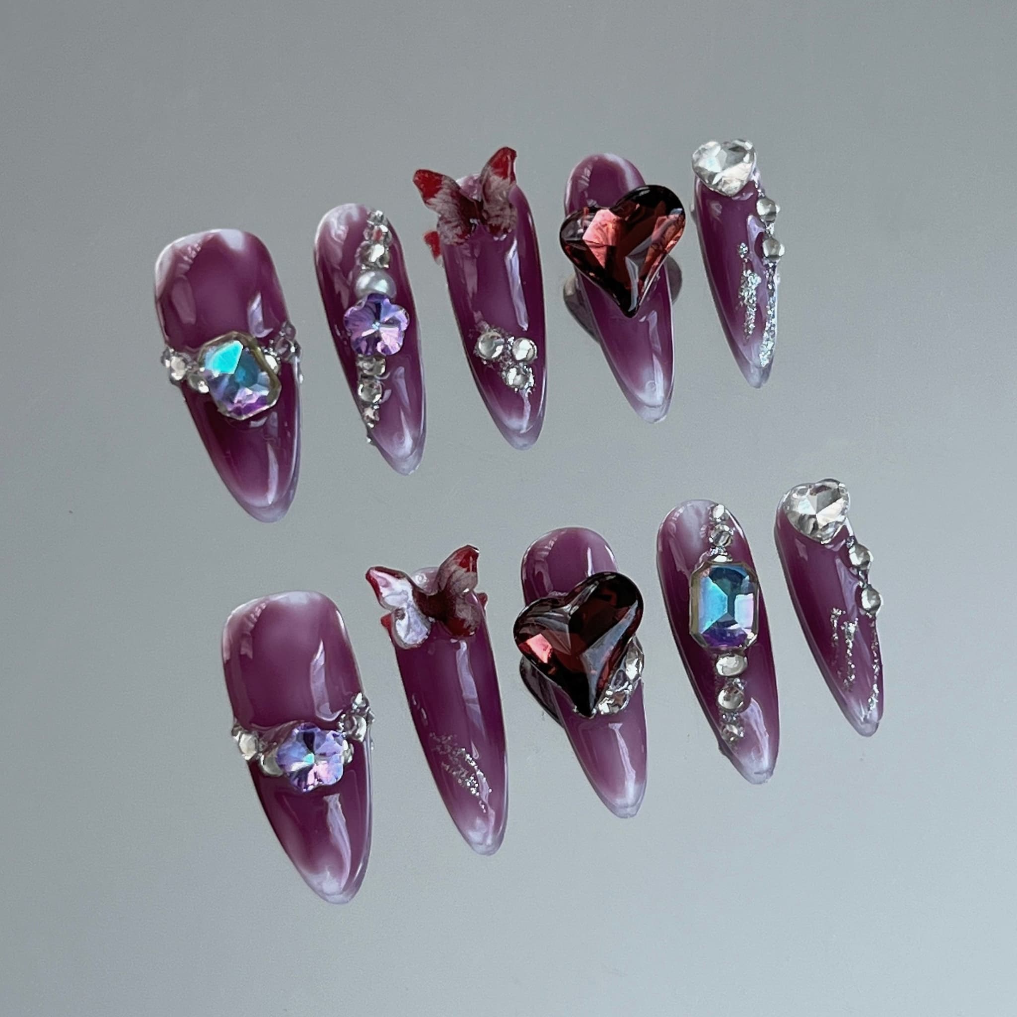 long length dark violet almond press on nails with heartshape charms, butterfly charms and jewellery charms