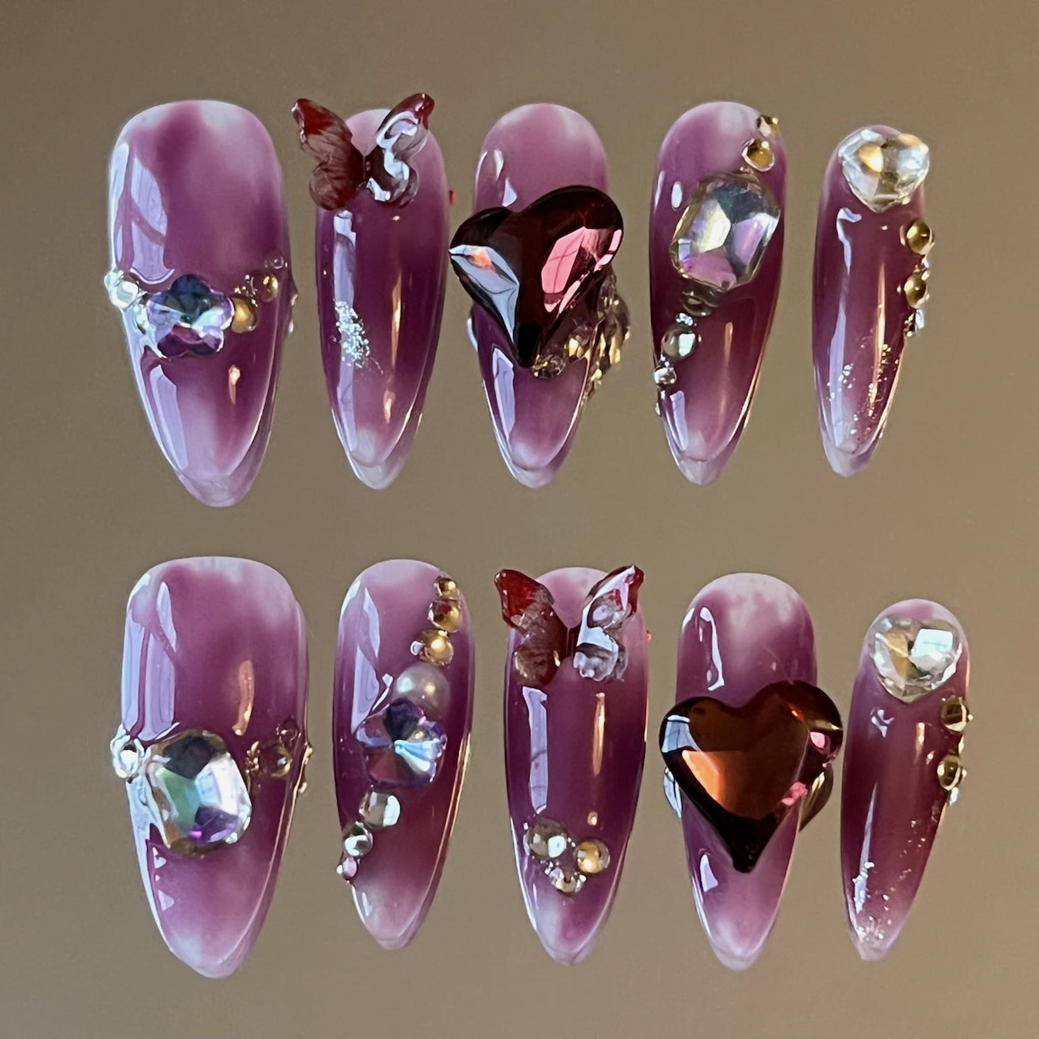long length dark violet almond press on nails with heartshape charms, butterfly charms and jewellery charms